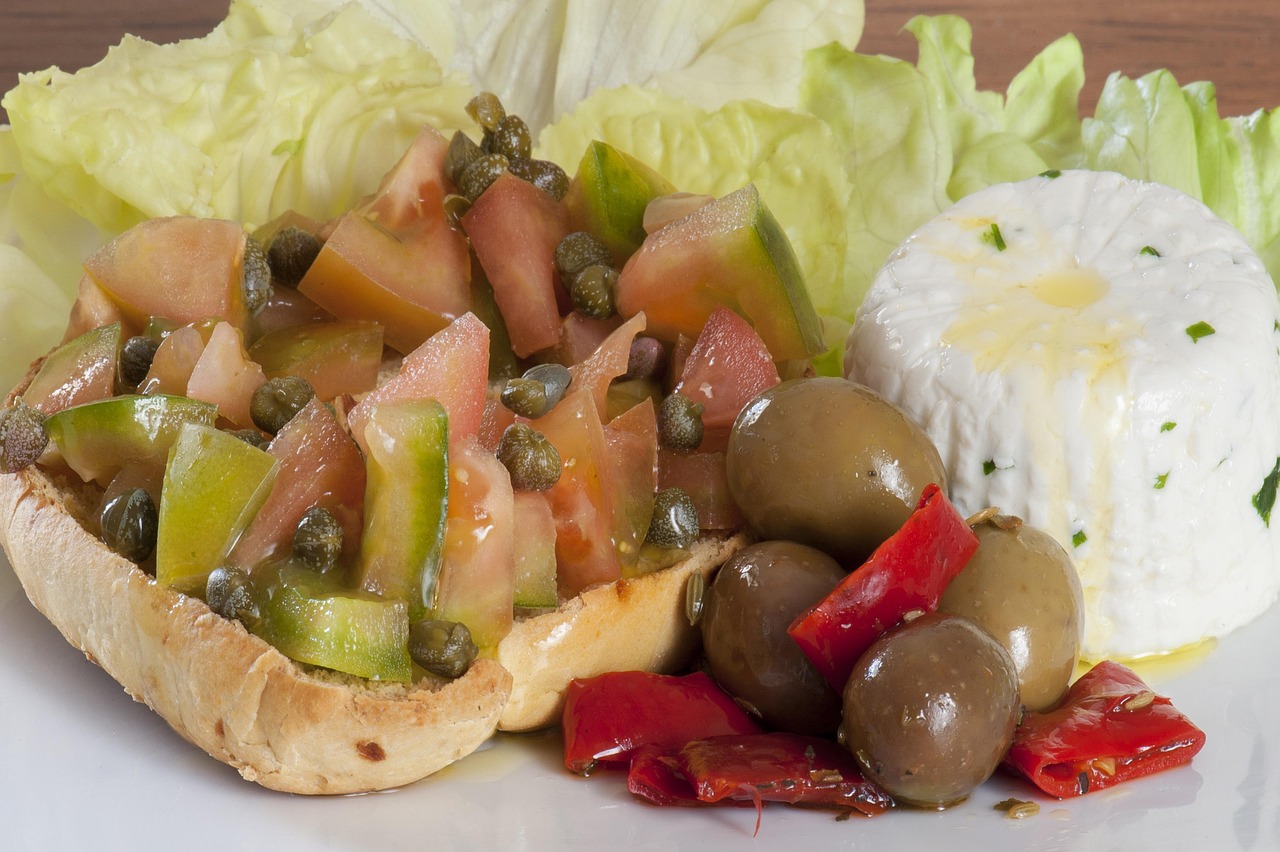 Caponata siciliana servita in un piatto, con melanzane, pomodori, olive e capperi.