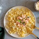 Pasta con crema di gamberi, piatto gourmet colorato e invitante, servito in un elegante piatto bianco.