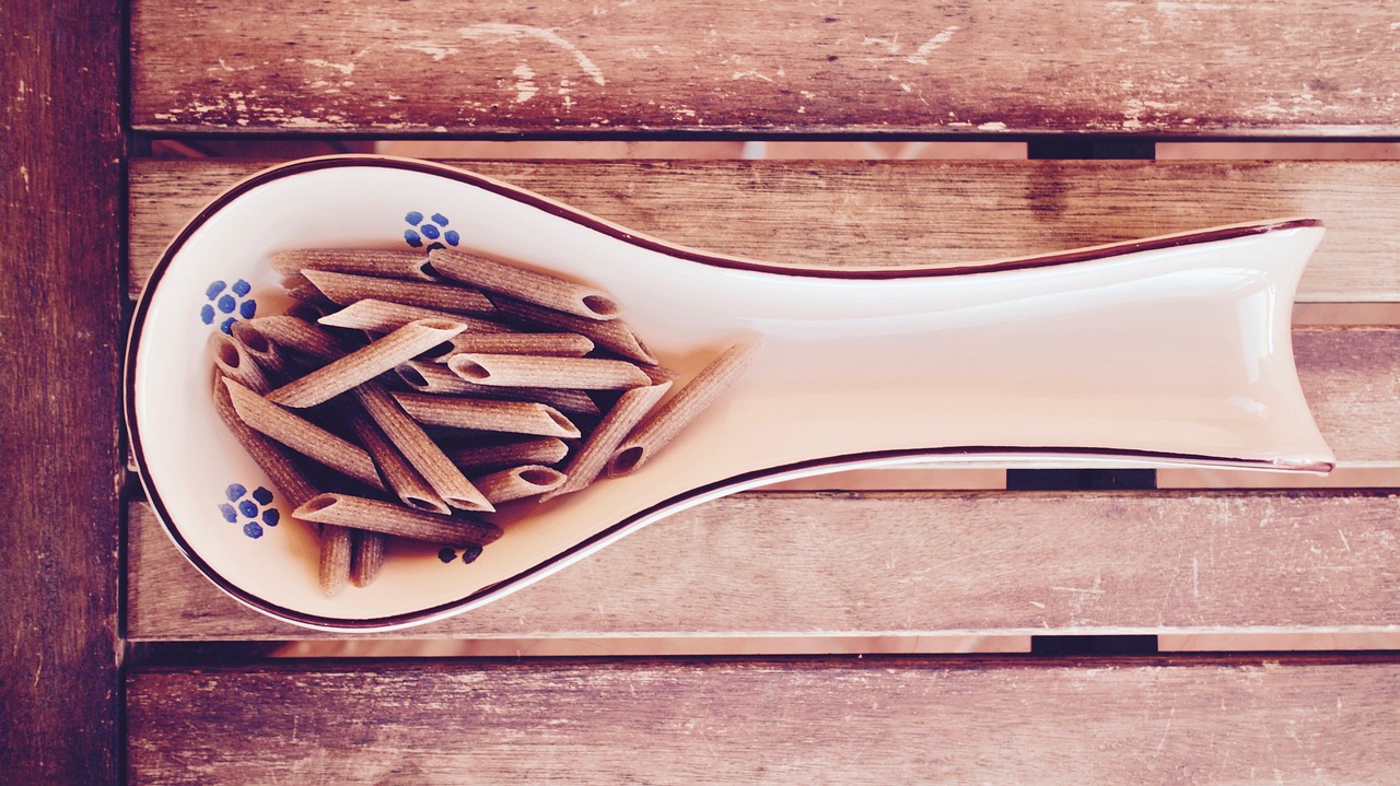 Pasta integrale con verdure fresche e condimento, piatto salutare e gustoso.