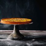 Crostata morbida appena sfornata, con una crema soffice e decorazioni di frutta fresca.